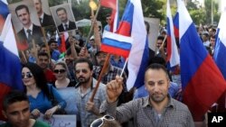 This photo from the Syrian news agency SANA shows Syrians in front of the Russian Embassy in Damascus expressing their thanks to Russia for its intervention, Oct. 13, 2015. Few Syrians who leave their country, however, are finding Russia to be a safe haven.