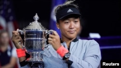 Naomi Osaka memamerkan piala turnamen AS Terbuka seteleh mengalahkan Serena Williams di final tunggal putri AS Terbuka yang berlangsung di USTA Billie Jean King National Tennis Center di New York, 8 September 2018. (R. Deutsch/USA Today)