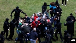 People clash with policemen during an opposition rally to protest the official presidential election results in Minsk, Belarus, Oct. 11, 2020.