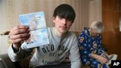 Remaja Rusia, Alexander Abnosov didampingi neneknya menunjukkan paspor Amerikanya kepada para wartawan di Cheboksary, Rusia (20/3). 