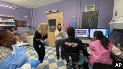In this Friday, March 13, 2020 photo provided by Regneron, members of the Infectious Disease team celebrate at their lab in New York state after confirming cells from Singapore are usable. (Regeneron via AP)