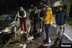 Local residents inspect a part of a suicide drone, which local authorities consider to be Iranian made unmanned aerial vehicles (UAVs) Shahed-131/136, shot down during a Russian overnight strike, amid Russia's attack on Ukraine, in Kyiv, Ukraine May 8, 2023.