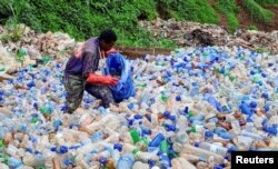 Congolese artist Patrick Cikuru Cirimwami collects plastic waste near the banks of the Ruzizi I hydroelectric plant, in Bukavu, eastern Democratic Republic of Congo on December 14, 2022. (REUTERS/Crispin Kyalangalilwa)