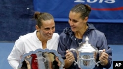 Flavia Pennetta, kanan, dan Roberta Vinci dengan piala mereka dalam turnamen AS Terbuka di New York, 12 September 2015.