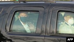 ប្រធានាធិបតី​សហរដ្ឋអាមេរិក​លោក Donald Trump ជិះ​ក្នុង​រថយន្ដ​នៅ​កៅអី​ខាង​ក្រោយ នៅ​ខាង​ក្រៅ​មន្ទីរពេទ្យ​យោធា Walter Reed ​ដើម្បី​ជួប​ជាមួយ​នឹង​ក្រុម​អ្នកគាំទ្រ​លោក ខណៈ​ពេល​មាន​ជំងឺ​កូវីដ១៩ ក្នុង​ក្រុង Bethesda រដ្ឋ Maryland ជាយ​រដ្ឋធានី​វ៉ាស៊ីនតោន ថ្ងៃទី ៤ ខែតុលា ឆ្នាំ​២០២០។ 