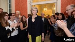 បុគ្គលិក​នានា​ទះ​ដៃ​នៅ​ពេល​ដែល​លោកស្រី Theresa May ដែល​ជា​នាយក​រដ្ឋ​មន្រ្តី​ថ្មី​របស់​អង់គ្លេស​ដើរ​ចូល​ទៅ​ក្នុង​វិមាន​នាយក​រដ្ឋ​មន្រ្តី 10 Downing Street នៅ​កណ្តាល​ក្រុង​ឡុងដ៍ ប្រទេស​អង់គ្លេស កាលពី​ថ្ងៃទី១៣ ខែកក្កដា ឆ្នាំ២០១៦។