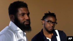 In this Wednesday, April 18, 2018 photo, Rashon Nelson, left, and Donte Robinson, right, listen to a reporter's question during an interview with The Associated Press in Philadelphia. (AP Photo/Jacqueline Larma)