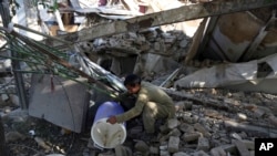 Wani dan kasar Afghanistan yana duba ko zai ga ragowar wani abin amfani bayan hari da ya sauka akan gidansa a Kabul