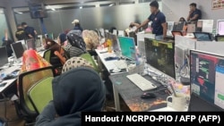 Polisi mengawasi para karyawan perusahaan penipuan yang dikelola warga China saat penggerebekan di gedung perkantoran di Manila. (Foto: via AFP)
