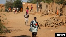 Des écoliers se hâtent de rentrer chez eux après avoir entendu des tirs à Gao, le 21 fév. 2013.