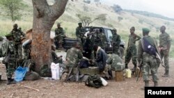 Les soldats congolais des Forces armées de la République démocratique du Congo (FARDC) prennent une pause pendant leur offensive contre les rebelles des Forces démocratiques pour la libération du Rwanda (FDLR) dans le village de Kirumba du territoire de Rutshuru en République démocratique du Congo, 27 février 2015. 