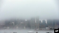 Fog shrouds Boston Harbor and obscures the skyline, Jan. 6, 2014, in Boston.