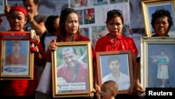 Anti-government ''red shirt'' protesters hold pictures of killed friends, relatives and late Italian photographer Fabio Polenghi, Bangkok's, May 19, 2011.