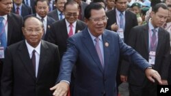 Cambodia's Prime Minister and President of the People's Party, Hun Sen, center, arrives at an event marking the 38th anniversary of the 1979 downfall of the Khmer Rouge regime in Phnom Penh, Cambodia, Saturday, Jan. 7, 2017. (AP Photo/Heng Sinith)