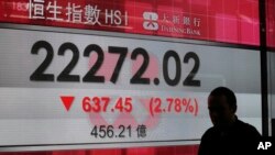 A man walks past a display of the Hang Seng Index at a bank in Hong Kong, Nov. 9, 2016.