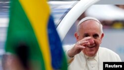 Pope Francis waves to faithful as he arrives at Sao Joaquim Palace in Rio de Janeiro, July 26, 2013. 