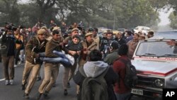 Seorang demonstran ditahan oleh seorang polisi di luar Uttar Pradesh Bhawan saat berlangsungnya aksi protes terhadap UU kewarganegaraan baru dan kekerasan oleh polisi di negara bagian itu, di New Delhi, India, 27 Desember 2019.