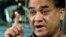 FILE - Ilham Tohti, a champion of China's Uighur minority who was jailed last year and whose plight is being highlighted by the "Press Uncuffed: Free the Press" campaign, gestures during an interview in his Beijing home, Feb. 4, 2013.