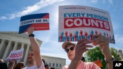Immigration activists rally outside the Supreme Court as the justices hear arguments over the Trump administration's plan to ask about citizenship on the 2020 census, in Washington, April 23, 2019. 