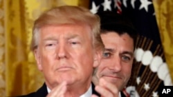 FILE - President Donald Trump applauds with House Speaker Paul Ryan of Wisconsin behind him in the East Room of the White House, July 26, 2017.