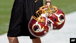 FILE - Washington Redskins football helmets are seen before a game in Landover, Maryland, Aug. 19, 2016. 