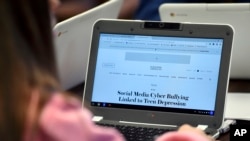 In this, Dec. 20, 2017 photo, Ariana Mamudi, 14, a freshman in the Brookfield, Conn., High School Digital Student class, searches for information about Cyber Bullying. 