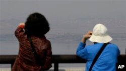 Visitors watch North Korean side at unification observation post near the border village of Panmunjom, north of Seoul, April 1, 2014.