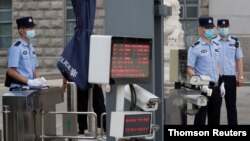 ប៉ូលិស​ឈរ​យាម​នៅ​ច្រក​ចេញចូល​តុលាការ​កណ្តាល​លេខ ២ ប្រចាំ​ក្រុង​ប៉េកាំង។