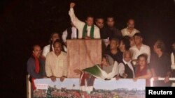 Pakistani opposition politician Imran Khan (C) waves while addressing supporters in Islamabad August 17, 2014.