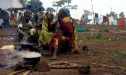 FILE - Congolese families, who fled from the Democratic Republic of Congo, prepare meals at United Nations High Commission for Refugees' (UNHCR) Kyangwali refugee settlement camp, Uganda, March 19, 2018.