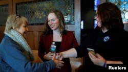 FILE - Democratic candidate for the U.S. Congress Alexandra Chandler, center, a transgender, former Naval Intelligence analyst, introduces her wife Cathy, right, to a voter in Haverhill, Massachusetts, Jan. 27, 2018. 