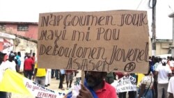 Protester in Port-de-Paix, Haiti holds sign that reads: "We'll fight until the corn gets ripe to untangle ourselves from killer Jovenel", during a protest to demand the president resign, Oct. 4, 2019. (Photo: Lucson Palmeus / VOA Creole)