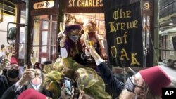 Members of the Krewe of Oak toast Carnival as the Phunny Phorty Phellows start their 40th anniversary streetcar ride in New Orleans, Wednesday, Jan. 6, 2021. (David Grunfeld/The Times-Picayune/The New Orleans Advocate via AP) 