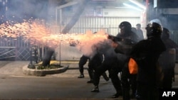 Indonesian police officers shoot tear gas to disperse protesters during a demonstration outside the Elections Oversight Body in Jakarta, Indonesia, May 22, 2019.
