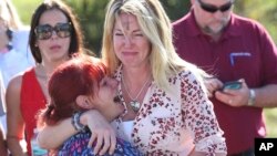 Parents wait for news after a reports of a shooting at Marjory Stoneman Douglas High School in Parkland, Fla., on Feb. 14, 2018. 