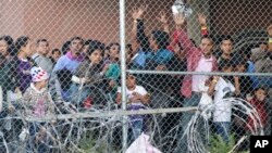 In this March 27, 2019, file photo, Central American migrants wait for food in a pen erected by U.S. Customs and Border Protection to process a surge of migrant families and unaccompanied minors in El Paso, Texas. 