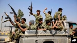 FILE - Shiite fighters, known as Houthis, ride on a patrol truck as they chant slogans during a tribal gathering showing support for the Houthi movement in Sanaa, Yemen. 