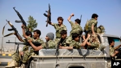 FILE - Houthi fighters ride on a patrol truck as they chant slogans during a tribal gathering in Sana'a, Yemen, Dec. 14, 2015. 