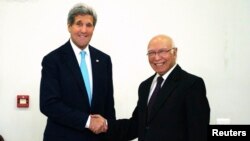 U.S. Secretary of State John Kerry shakes hands with Pakistan's National Security Advisor Sartaj Aziz (R) before a meeting in Islamabad, January 13, 2015.