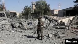 FILE - A police trooper walks on the rubble of a building destroyed by Saudi-led air strikes at Sana'a Airport in Sana'a, Yemen, Dec. 21, 2021. 