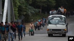 Honduran migrant Omar Orella pushes fellow migrant Nery Maldonado Tejeda in a wheelchair, as they travel with hundreds of other Honduran migrants making their way to the U.S., near Chiquimula, Guatemala, Oct. 16, 2018. Maldonado said he lost his legs in 2015 while riding "The Beast," a northbound cargo train that crosses Mexico, and that this was his second attempt to reach the U.S.
