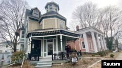 Kate and Cameron Reinhart stand on the porch of their 1880's Octagon house they are renovating during the coronavirus pandemic, in Norwich, eastern Connecticut, U.S., January 14, 2021. (REUTERS/Dan Fastenberg)