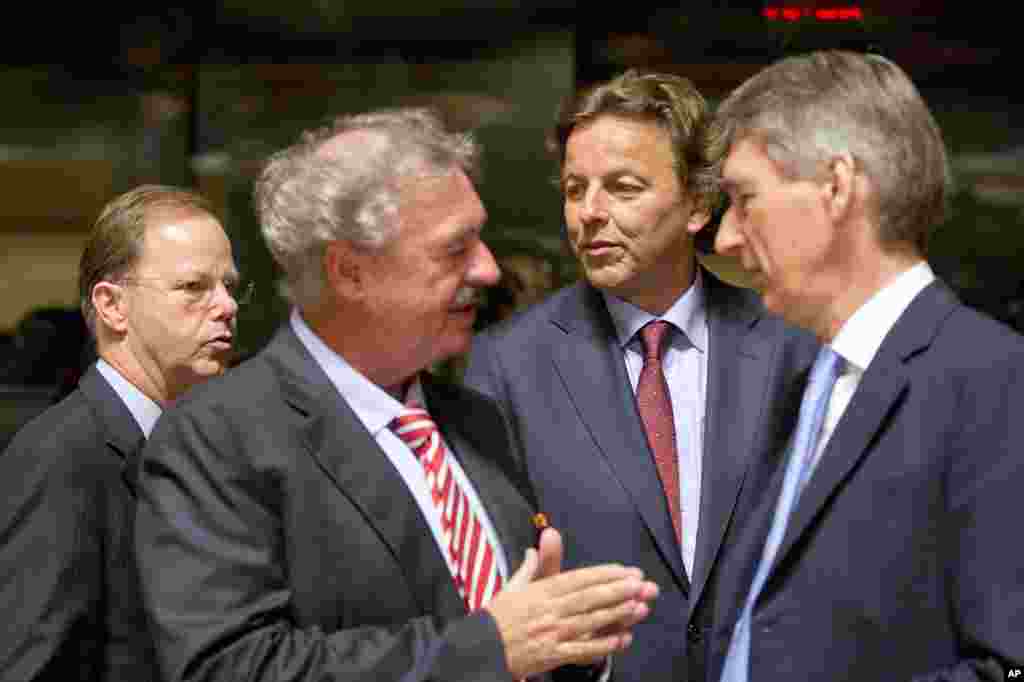 Dutch Foreign Minister Bert Koenders, center, speaks with Luxembourg&#39;s Foreign Minister Jean Asselborn, second left, and British Foreign Minister Philip Hammond, right, during a round table meeting of EU foreign ministers in Luxembourg on Monday, Oct. 20, 2014. European Union nations are working to find funds to help fight Ebola in West Africa and streamline a common approach in dealing with the health crisis. 