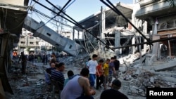 Warga Palestina berkumpul dekat masjid yang menurut polisi hancur akibat serangan udara Israel di Gaza, 30 Juli 2014. 