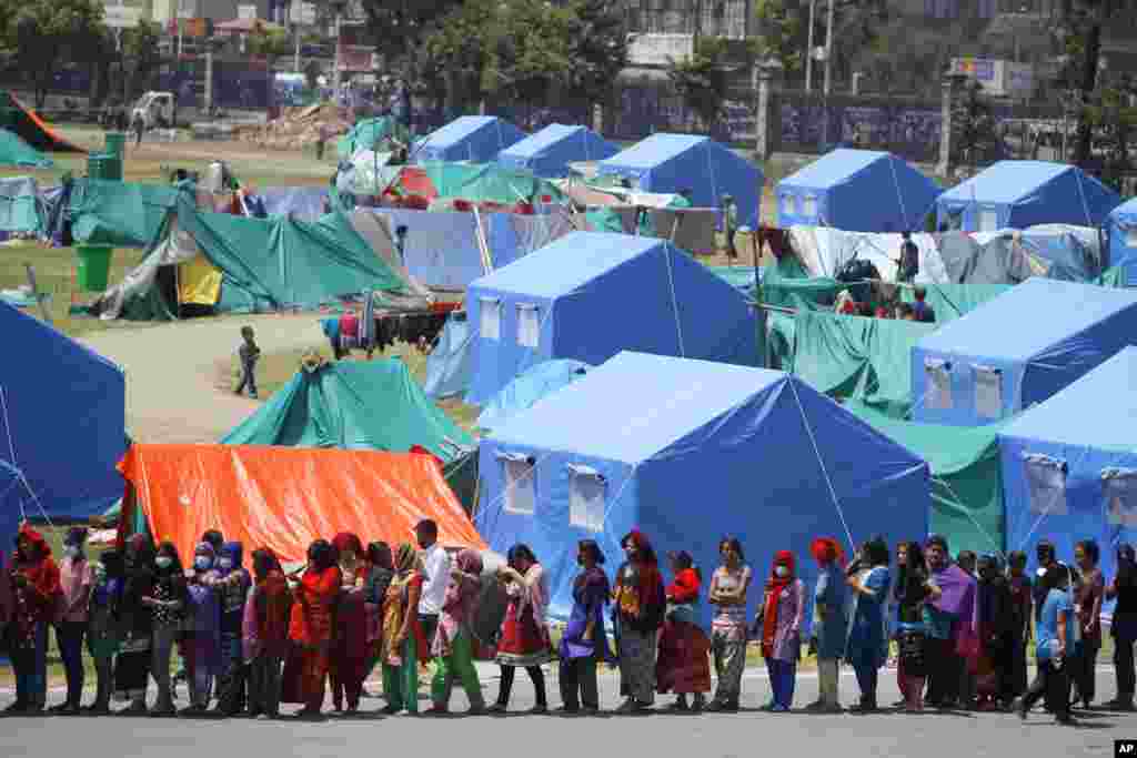 People are now living in tents because their homes were damaged in the April 25 earthquake. They line up to receive donated drinking water and packaged noodles, in Kathmandu, Nepal, May 3, 2015.