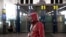 A traveler wears a respirator, goggles, and a raincoat as he walks through Beijing Capital International Airport, in Beijing, China, March 28, 2020.