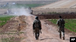 FILE - Turkish soldiers patrol near the border with Syria, ouside the village of Elbeyli, east of the town of Kilis, southeastern Turkey, July 24, 2015.