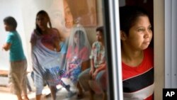 FILE PHOTO - Mariana Bulu, right, a former maid takes refuge at a temporary shelter for abused and mistreated maids before departing back to Indonesia at the Indonesian Embassy in Kuala Lumpur, Malaysia, Monday, July 2, 2007. (AP Photo/Marcus Yam)