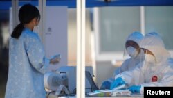 11일 한국 용인에서 설치된 신종 코로나바이러스 감염증(COVID-19) 격리 센터에서 바이러스 확진자가 21대 국회의원 선거 사전투표를 하기 위해 투표소에 도착했다. 