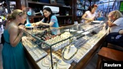 Tourists look at jade and gems in a shop at Aung San market in Rangoon, Burma.